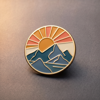 Emaille-Pin: runde Anstecknadel mit Goldrand, Sonnenuntergang und Bergen